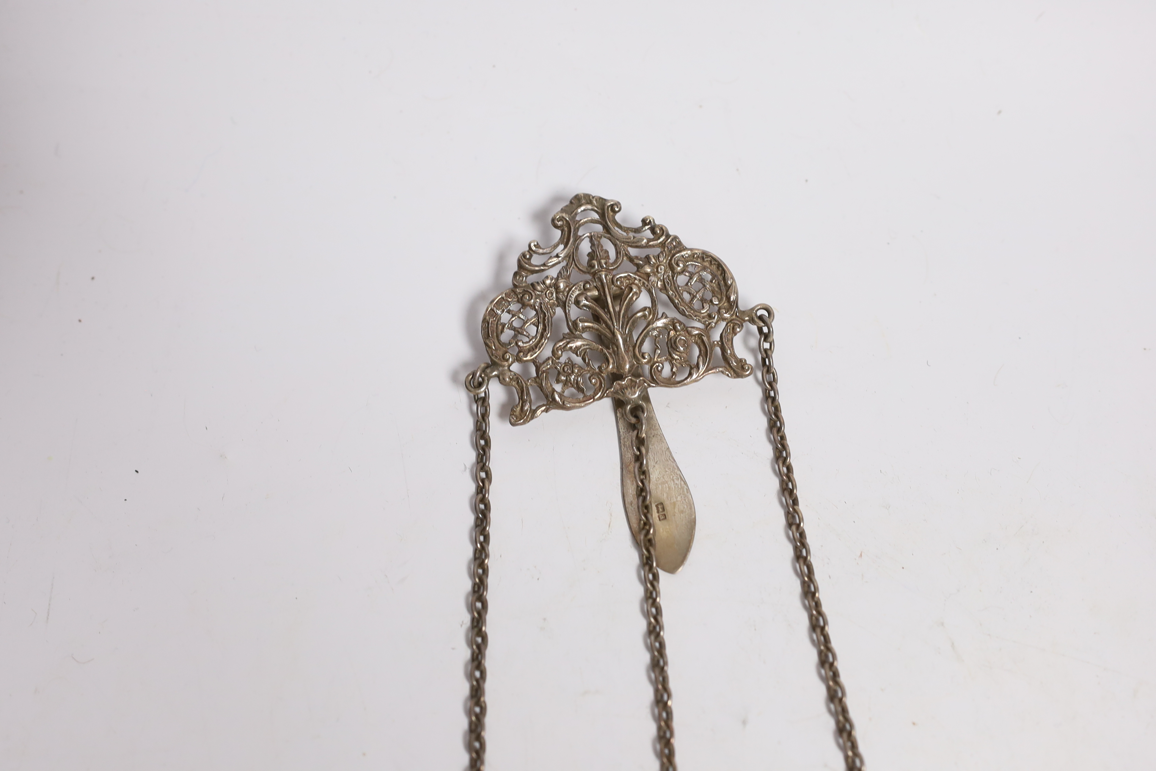 A late Victorian pierced silver chatelaine by Levi & Salaman, Birmingham, 1900, hung with three assorted accoutrements to include an unmarked mesh purse, pocket knife with button hook and a Swiss 935 fob watch, overall 2